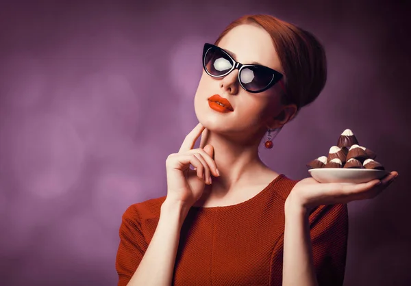 紫色の背景にキャンディと赤毛の女性 — ストック写真