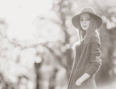 Kızıl saçlı kız şapka ve kazak sonbahar parkta.