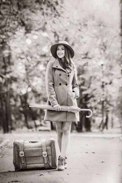 傘と秋の公園でスーツケースを持つ少女 黒と白の色のイメージ — ストック写真