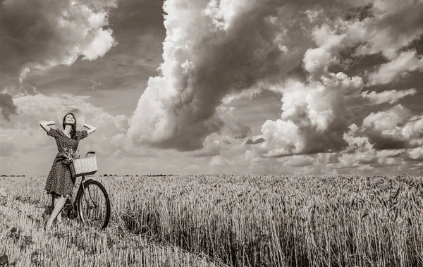 麦畑に自転車を持つ少女 黒と白の色のイメージ — ストック写真