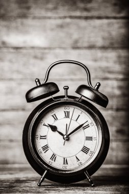 ahşap masa üstünde çan olan klasik çalar saat