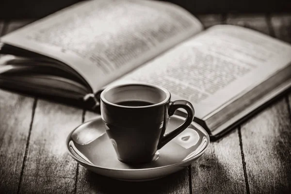 Cup of coffee and open book on a wooden table — Stock Photo, Image