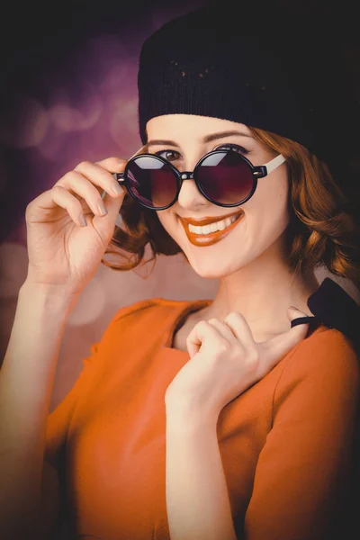 ベレー帽 灰色の背景のサングラスに身を包んだ巻き毛を持つ美しい少女の肖像画 — ストック写真