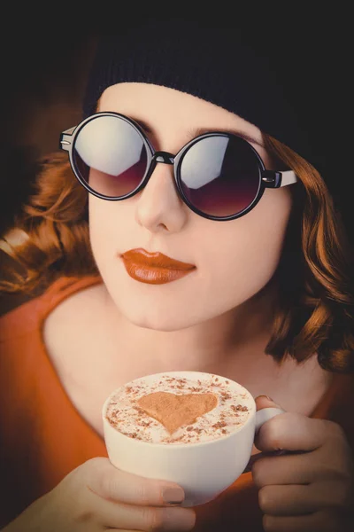 Dziewczyna z kręconymi włosami trzymając kubek kawy — Zdjęcie stockowe
