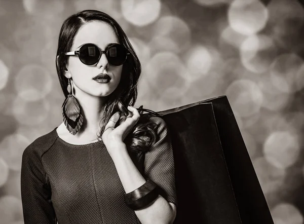 Mujer en vestido y gafas de sol con bolsa de compras —  Fotos de Stock