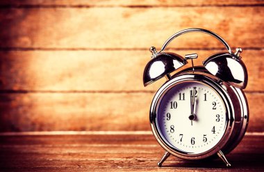 ahşap bir masa üzerinde gri metal çalar saat