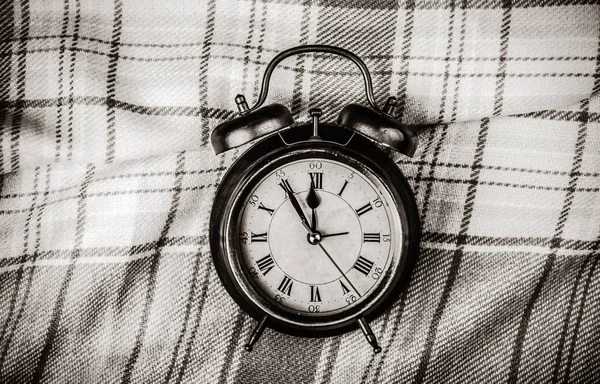 Relógio despertador e cachecol no fundo . — Fotografia de Stock