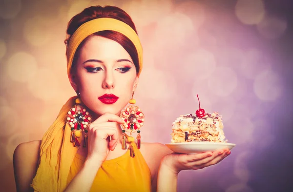 Stijl roodharige meisje met cake. — Stockfoto