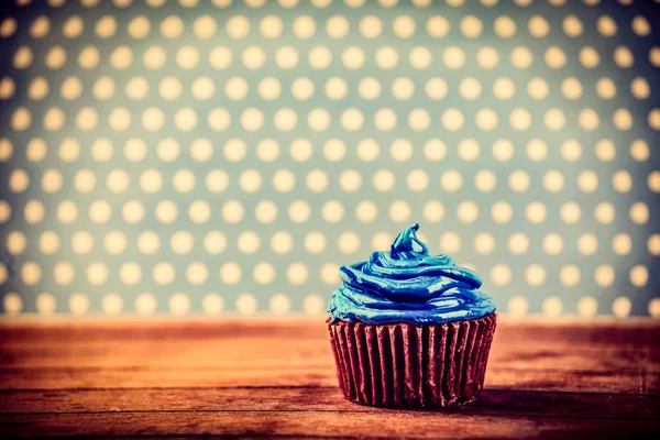 Blauwe cream cupcake op houten tafel — Stockfoto