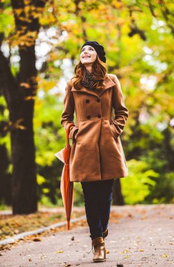 Kızıl saçlı kız ceket şemsiye ile