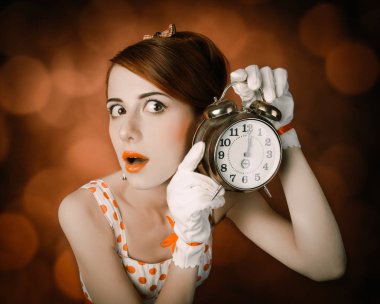 Saati ile sürpriz Kızıl saçlı kadın. Retro tarzı ile bokeh arka plan, fotoğraf.