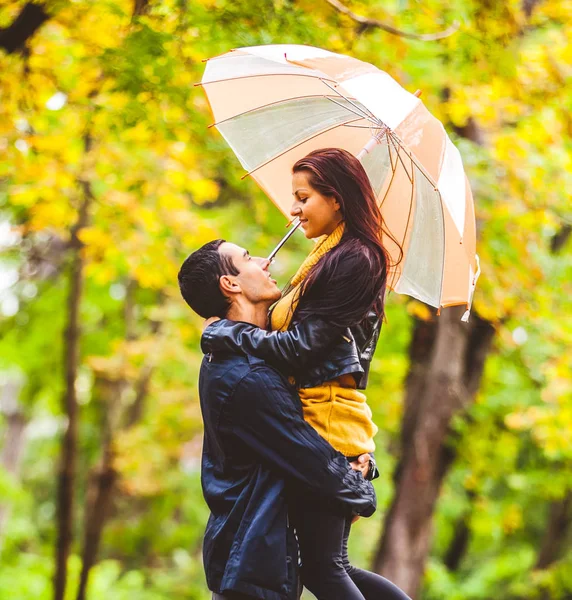 Young couple in love with umbrella kissing — Stock Photo, Image