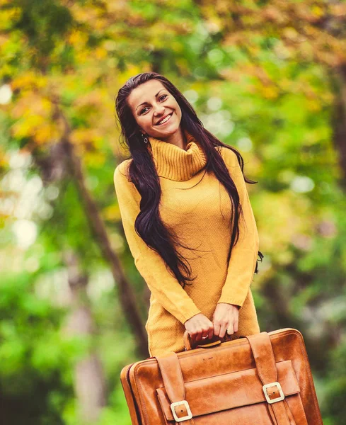 Niña sosteniendo la maleta en el callejón de otoño — Foto de Stock