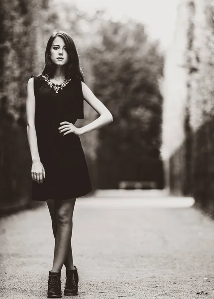 Belle femme en robe noire dans les jardins versailles . — Photo