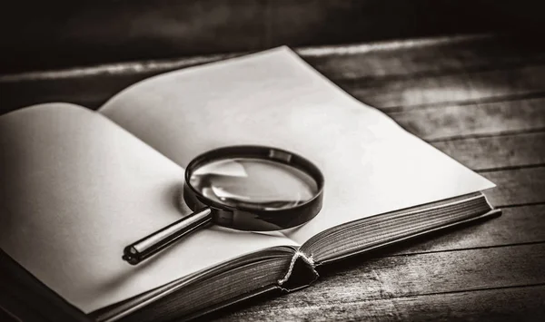 Magnifying glass and book — Stock Photo, Image