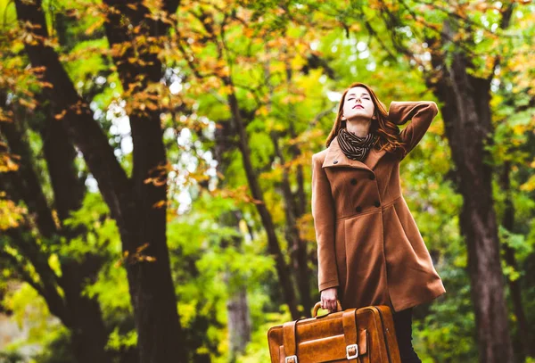 Redhead girl in beret and coat with suitcase — Stock Photo, Image