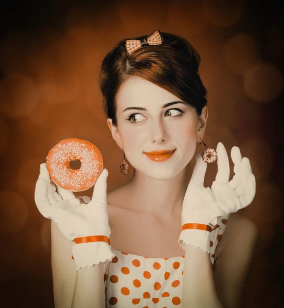 Mooie roodharige vrouw met donut. — Stockfoto