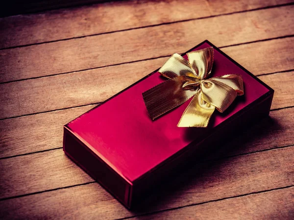 Red christmas gift box on wooden table — Stock Photo, Image