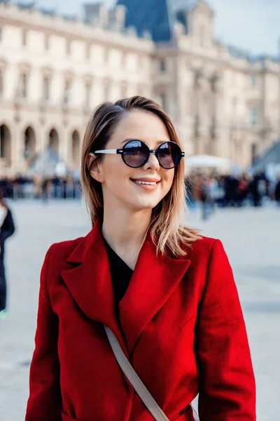 Rödhårig tjej i röd kappa och väska på parisisk gata — Stockfoto