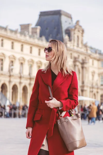 Руда дівчина в червоному пальто і сумка на паризькій вулиці — стокове фото