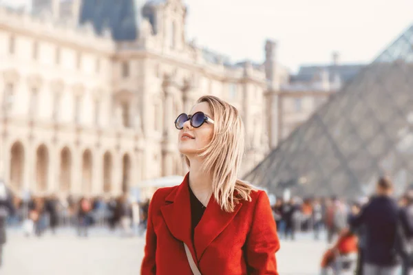 Rousse fille en manteau rouge et sac dans la rue parisienne — Photo