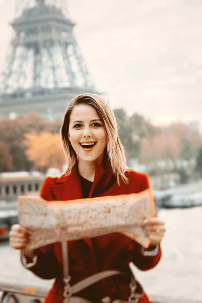 Ragazza in cappotto rosso con mappa in strada parigina — Foto Stock