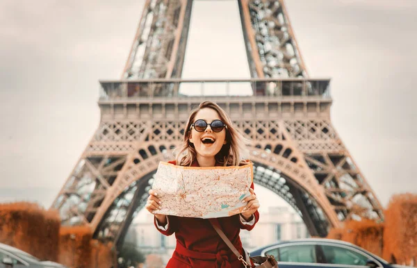 Niña en abrigo rojo y bolsa con mapa en el parque parisino — Foto de Stock