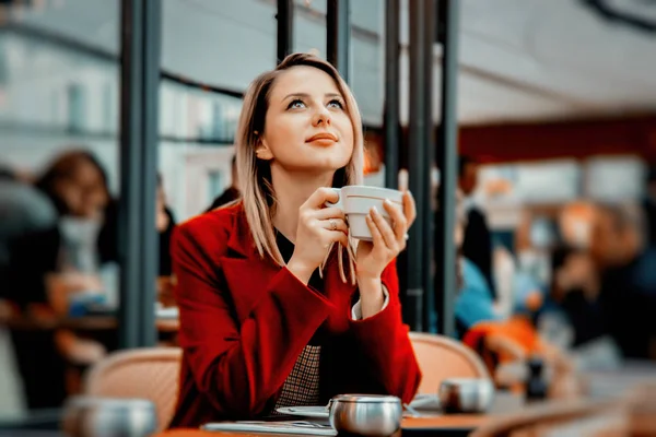 Dziewczyna w czerwonym płaszczu, z kubkiem kawy w paryskiej kawiarni — Zdjęcie stockowe