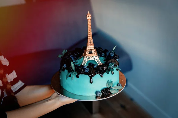 Hands holding cream cake with Eiffel tower — Stock Photo, Image