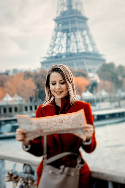 Ragazza in cappotto rosso con mappa in strada parigina — Foto Stock