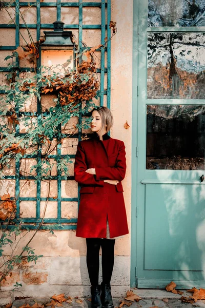 Ruiva menina em casaco vermelho ficar perto da casa do vintage — Fotografia de Stock