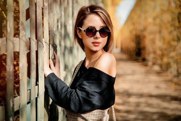 Ragazza in occhiali da sole nel parco stagione autunnale — Foto Stock