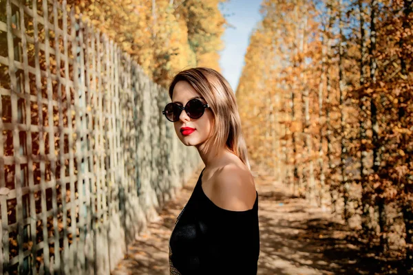 Fille dans les lunettes de soleil en automne saison parc — Photo