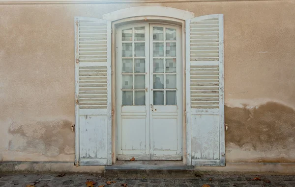 Выдержанные белые двери с окнами и ставнями — стоковое фото