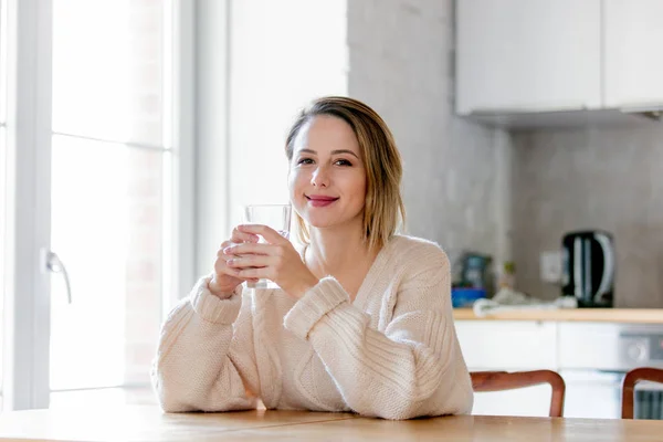 Young girl in sweater with glass of water — Stock Photo, Image