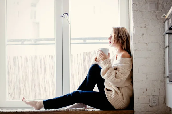Chica sentada en el umbral con una taza de café — Foto de Stock