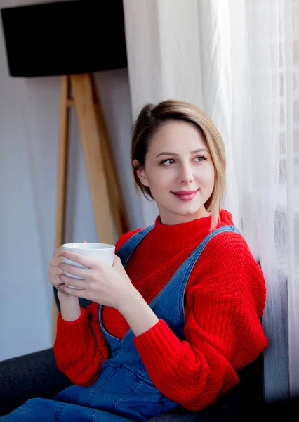 Ung flicka med kopp kaffe hemma — Stockfoto