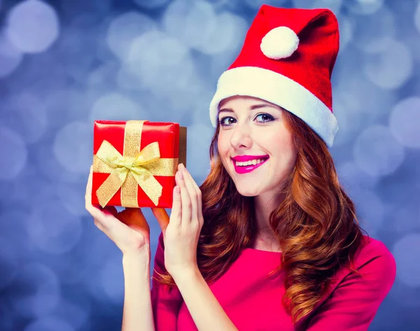 Mädchen in rotem Kleid und Hut mit Weihnachtsgeschenkschachtel — Stockfoto