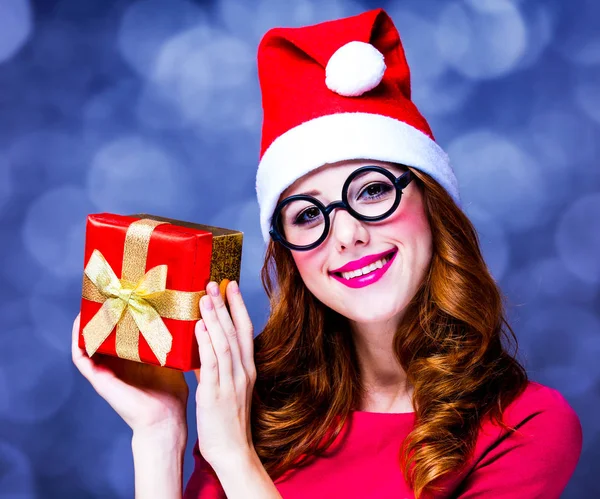 Lány piros ruhában és kalapban és karácsonyi ajándék doboz — Stock Fotó
