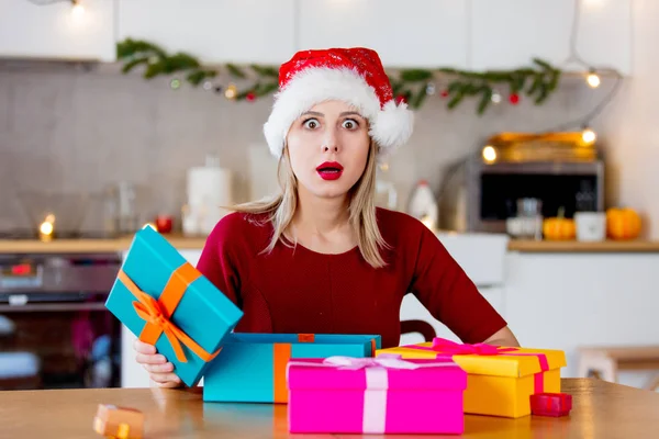 Menina no chapéu de Natal com caixas de presente — Fotografia de Stock