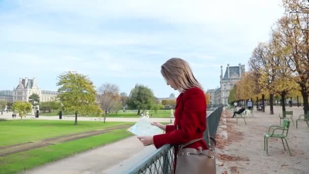 Chica de abrigo rojo con mapa en París — Vídeos de Stock