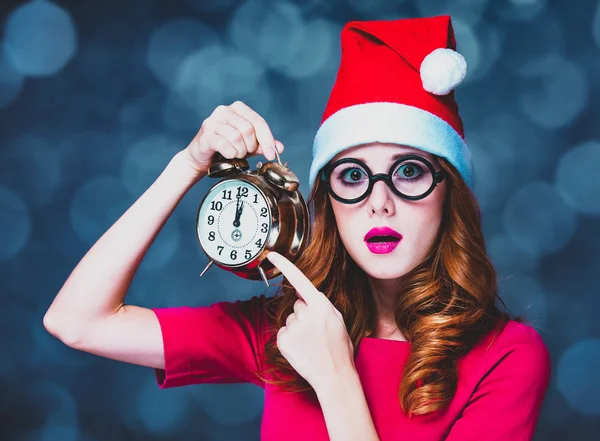 Chica en sombrero de Navidad celebración de reloj despertador —  Fotos de Stock