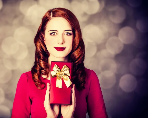 Style redhead woman in red dress with gift box — Stock Photo, Image