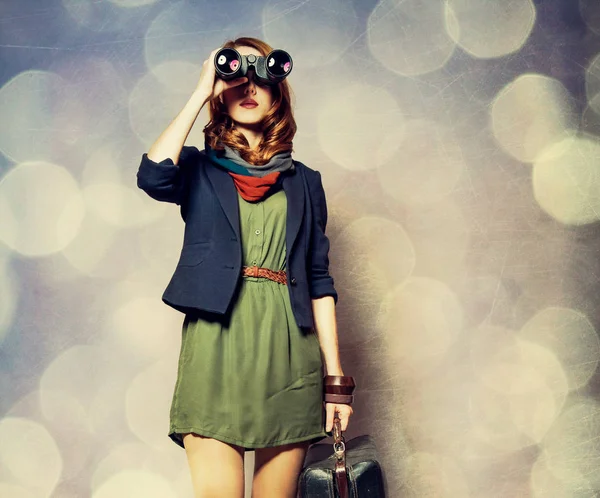 Rödhårig tjej med kikare och resväska — Stockfoto