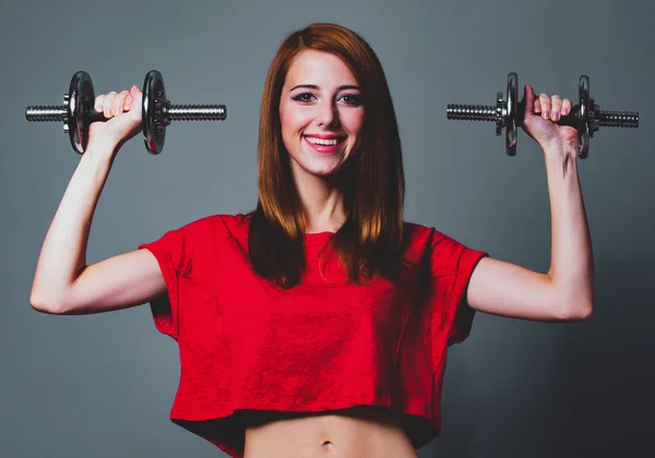 Sport kvinde i rød skjorte med håndvægte - Stock-foto