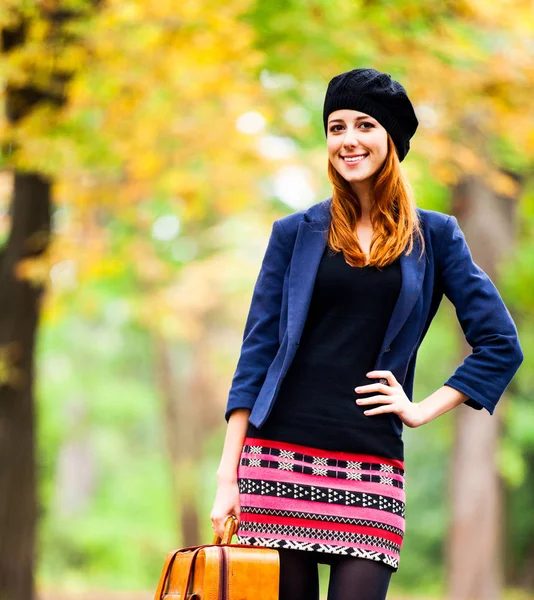 Style fille rousse en béret, veste et jupe avec valise — Photo