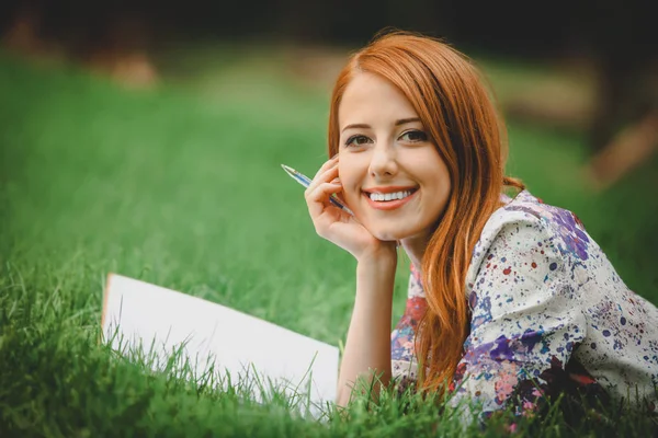 Kvinna med notebook på gräsmattan — Stockfoto