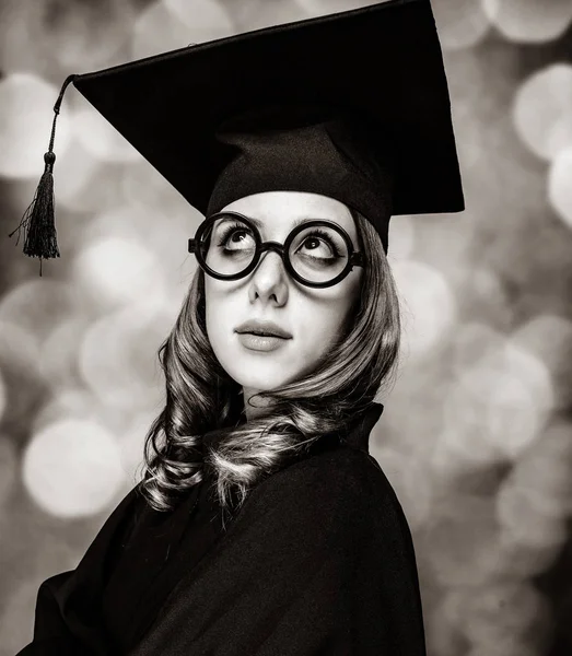 Dimitterende studerende pige i en akademisk kjole . - Stock-foto
