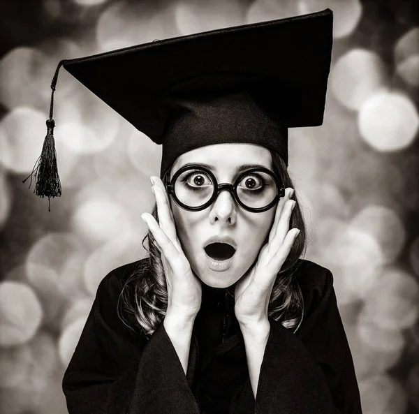 Examen student tjej i en akademisk klänning. — Stockfoto