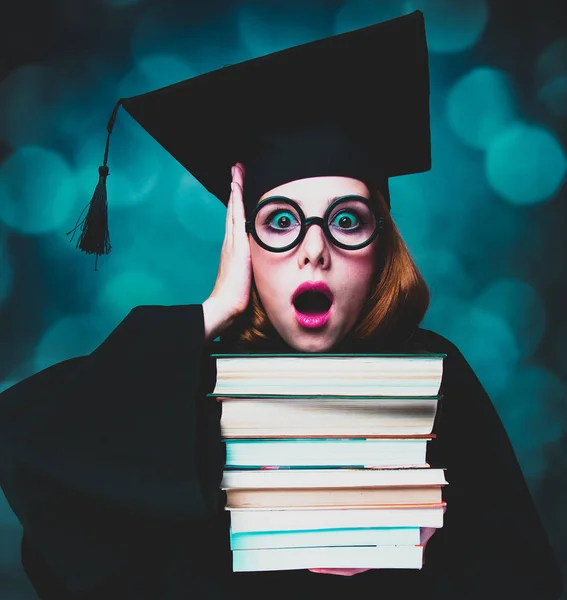Studente ragazza in un abito accademico con libri — Foto Stock